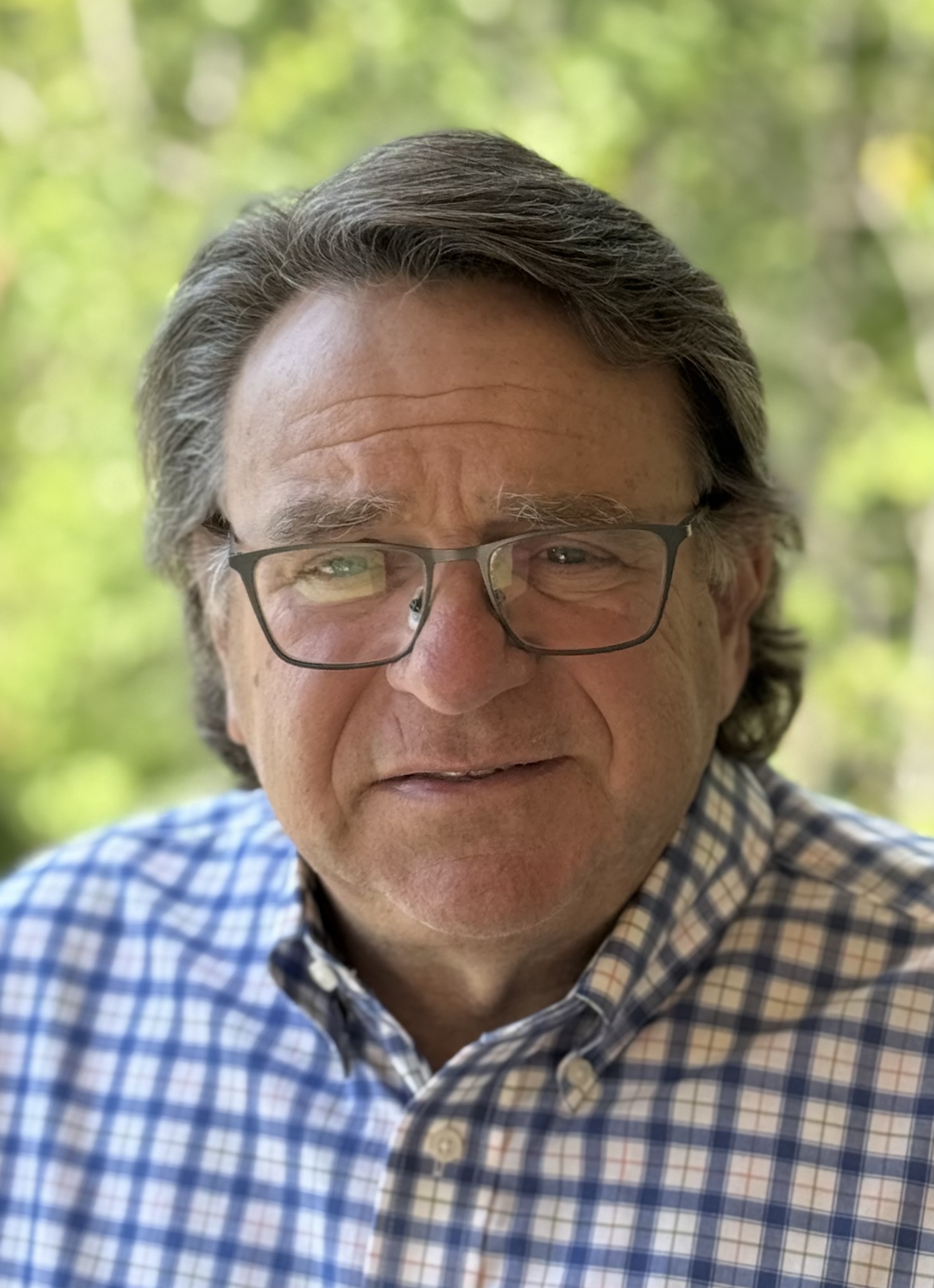 Portrait of John R. Rodgers, Jr., executive coach and author, smiling outdoors in a checked shirt